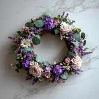 circular spring wreath crafted from fresh lavender eucalyptus leaves and tiny daisies rests on marble tabletop. Soft natural light bathes arrangement highlighting its vibrant colors photo