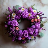 beautiful circular spring wreath is composed of vibrant lavender eucalyptus leaves and delicate daisies placed on marble tabletop. Soft natural light enhances fresh details photo