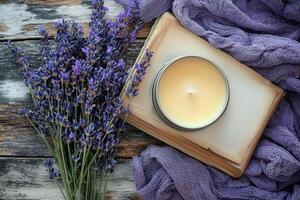 top down view displays beautifully designed scented candle in tin container on rustic wooden surface. Dried lavender and open book enhance serene ambiance photo