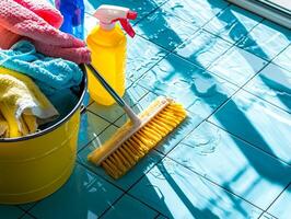 Brightly colored cleaning supplies are organized on tiled floor. mop sits next bucket filled towels and multiple spray bottles highlighting cleanliness and order in workspace photo