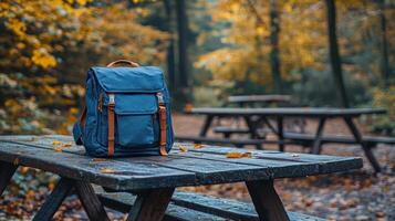 flat design mockup showcases customizable backpack resting on picnic table surrounded greenery in sunny park. Perfect for branding opportunities and outdoor promotions photo