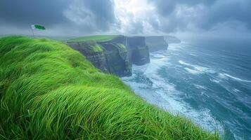 Waves crash against rugged cliffs of Moher as Irish flag flutters amidst lush green grass. Dark storm clouds loom above showcasing nature's dramatic beauty in Ireland photo