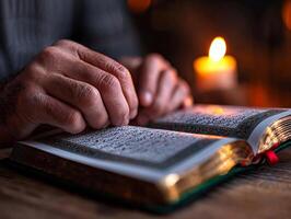 Hands uplifted in Dua are highlighted soft candlelight open Quran featuring beautiful Arabic calligraphy. moment reflects spirit of Eid al Fitr and unity photo