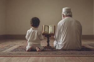 elderly man and young boy kneel together in quiet prayer space focusing on open Quran between them photo