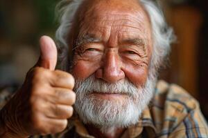 Smiling elderly Caucasian man giving a thumbs up, showcasing joy and positivity in a cozy indoor setting. photo