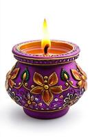 A beautiful handcrafted purple candle with intricate floral designs, glowing warmly with a flickering flame. photo