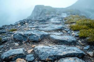 Mist-covered rocky path leading up a mountain, evoking a sense of adventure in nature. photo