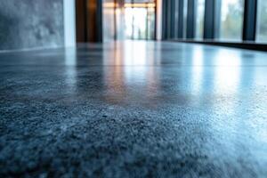 A sleek, polished concrete floor captures the modern architectural elegance of a spacious interior with large windows. photo