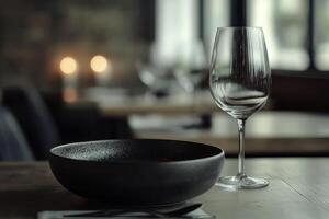 An elegant table setting featuring a sleek black plate and a crystal-clear wine glass, creating a sophisticated dining atmosphere. photo