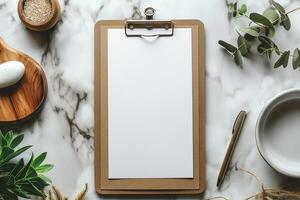 A blank clipboard on a marble surface surrounded by natural elements, perfect for creativity and planning. photo