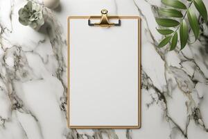 A blank clipboard on a marble surface surrounded by a plant and decorative elements. photo