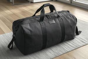 Stylish black duffle bag on a wooden floor, perfect for travel or gym use, featuring sleek design and durable material. photo