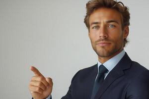 Confident young Caucasian man in a suit pointing to the side, showcasing professionalism and approachability. photo