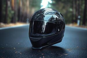 A sleek black motorcycle helmet placed on the road surrounded by trees, showcasing reflections and a glossy finish. photo