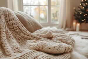 Cozy and inviting interior with a soft, knitted blanket draped over a plush surface, perfect for winter relaxation. photo