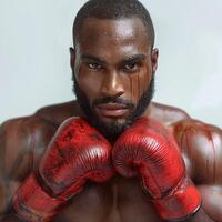 A strong Black male boxer with a fierce expression, wearing blood-stained red gloves, conveying intensity and determination. photo