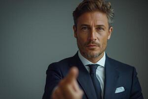A confident middle-aged Caucasian man in a tailored suit points directly at the viewer, exuding authority and self-assurance. photo