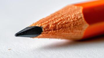 Close-up of an orange-colored pencil with a sharp black tip, showcasing intricate wood texture and vibrant color. photo
