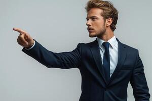 Confident young man in a suit pointing, exuding authority and determination. photo