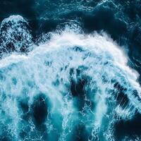 An aerial view of a wave breaking on the ocean photo