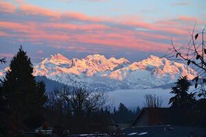 A view of a snowy mountain range from a house photo