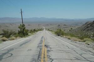 A long empty road in the desert with mountains in the background photo