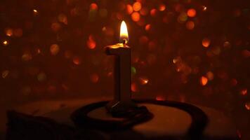Golden holographic background with shimmering movements. The candle flame flickers on a golden background. A birthday cake with a golden candle and the number 1. video