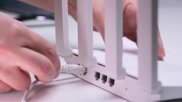 Technician plugging ethernet cable into wireless router in office setting video