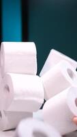 vertical Hand taking toilet paper roll from a large pile video