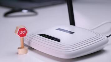 Hand placing stop sign in front of wireless router on desk video