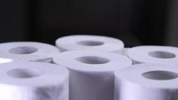 Many rolls of toilet paper forming a pyramid on a black background video