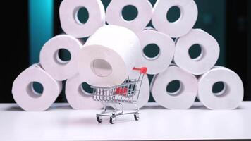 Hand placing toilet paper roll in shopping cart with stacked rolls in background video