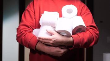 Man holding many toilet paper rolls at home. hoarding, panic buying, and fear of shortages video