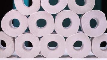 Stack of toilet paper rolls forming a pyramid on a white surface video