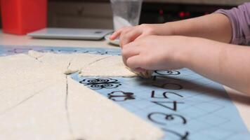 Child rolling dough into a croissant shape on a silicone baking mat video