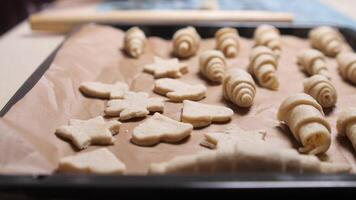 Pastry chef arranging unbaked croissants and cookies on baking sheet video