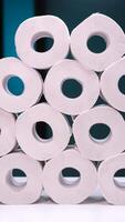 vertical Stack of toilet paper rolls forming a pyramid on a white surface video