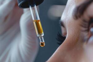Close-up of a dropper applying serum to a face photo