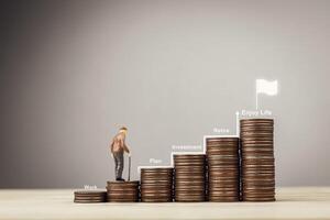 Concept of goal and long term stability. Stacks of coins according to money level with dolls of Elderly men. Meaning of working for retirement plan with investments or provident fund to enjoy life. photo