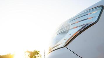 Close up of modern car headlight. Headlight is sleek and futuristic. Positioned against a bright sunny background, highlighting the car high-tech features and luxurious appearance. photo