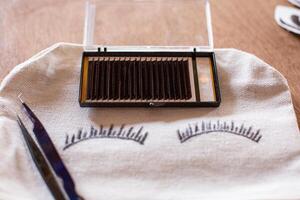 A pair of eyelashes and a pair of scissors on a table photo