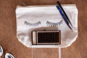 A bag with eyelashes on it and a pair of scissors photo