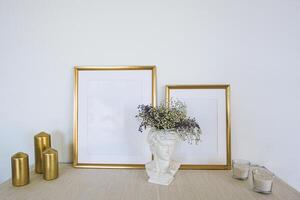 Gold frames on a table with flowers and candles photo
