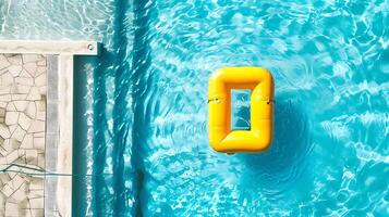 Swimming pool with yellow inflatable ring in swimming pool, top view photo