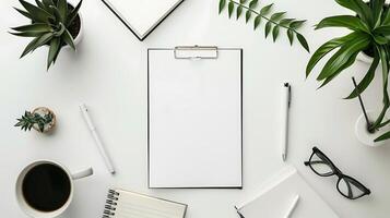 White office desk table with blank paper, coffee cup, stationery and copy space. Top view, flat lay photo