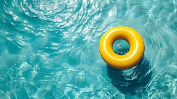 Yellow inflatable ring floating in the swimming pool. Summer background. photo