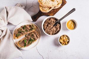 Sandwiches with chicken liver pate and herbs on a plate on the table top view photo