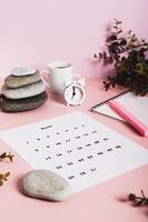 Monthly calendar and blank planning notebook on the desktop vertical view photo