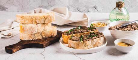Sandwiches with chicken liver pate and herbs on a plate on the table web banner photo