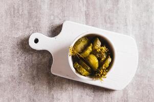Close up of sliced crispy pickled cucumbers in a bowl on the table top view photo